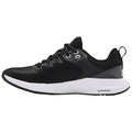 A black athletic shoe is displayed sideways showcasing its textured upper and contrasting white sole highlighting a sleek design suitable for running or casual wear in an outdoor or gym environment.