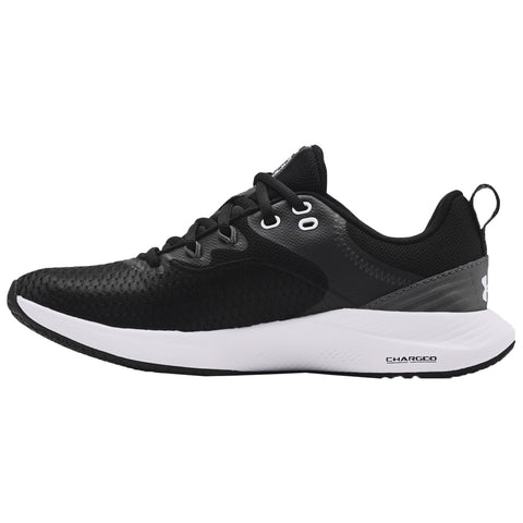 A black athletic shoe is displayed sideways showcasing its textured upper and contrasting white sole highlighting a sleek design suitable for running or casual wear in an outdoor or gym environment.
