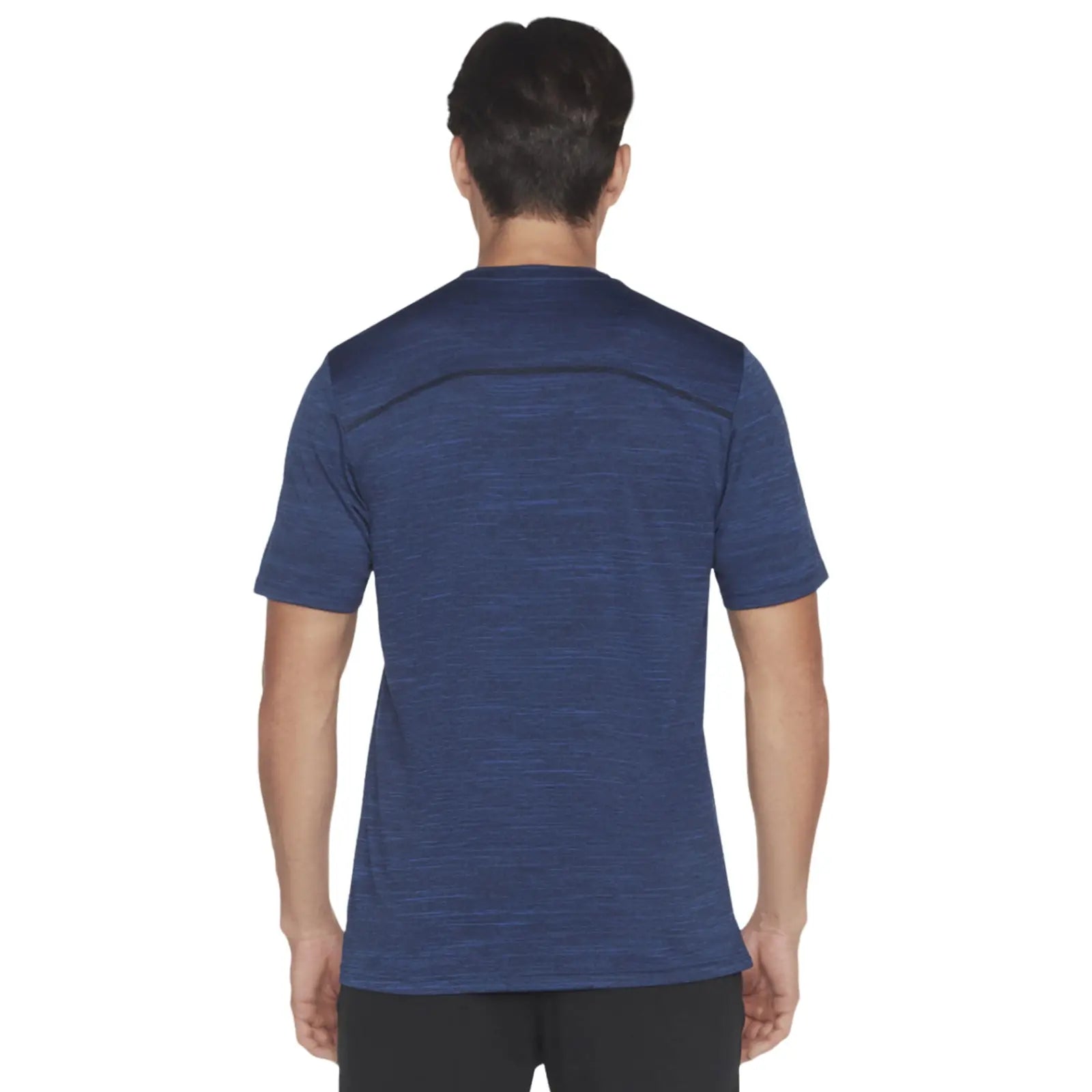 A person is wearing a short-sleeve blue athletic shirt facing away with a plain design and textured fabric in a neutral environment without notable background features.