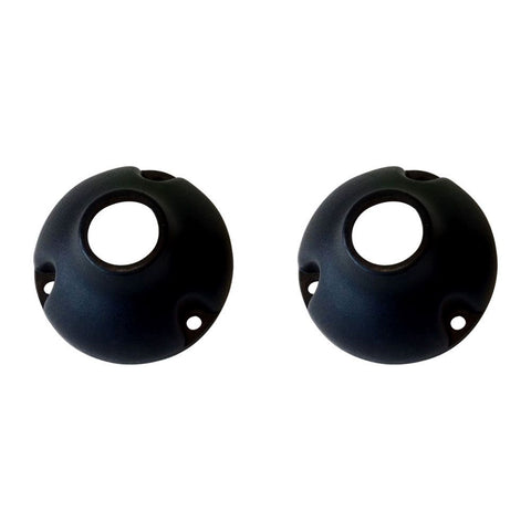 Two black spherical objects with a central hole and three smaller holes around the edge are placed side by side on a white background.