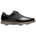 A black golf shoe is positioned on a plain background showcasing its smooth leather upper decorative perforations and spiked outsole designed for traction on golf courses.