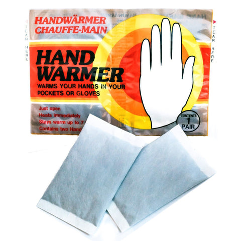 A package containing two hand warmers is shown next to two individual warmers. The warmers provide heat for hands in pockets or gloves, with instructions for use printed on the package.
