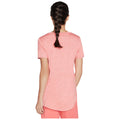 A person with a braided hairstyle is wearing a short-sleeve pink shirt and stands with their back to the viewer in a neutral setting.