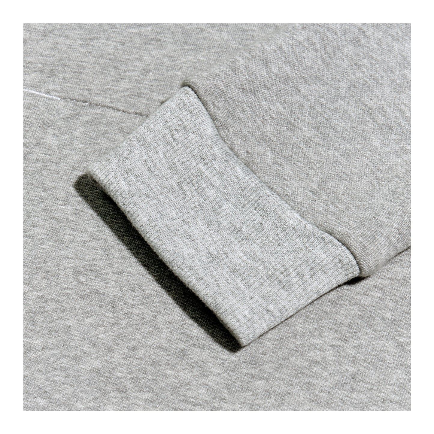 A gray sweatshirt is displayed prominently showing a close-up of a cuff where the fabric appears soft and textured against a uniform gray background.
