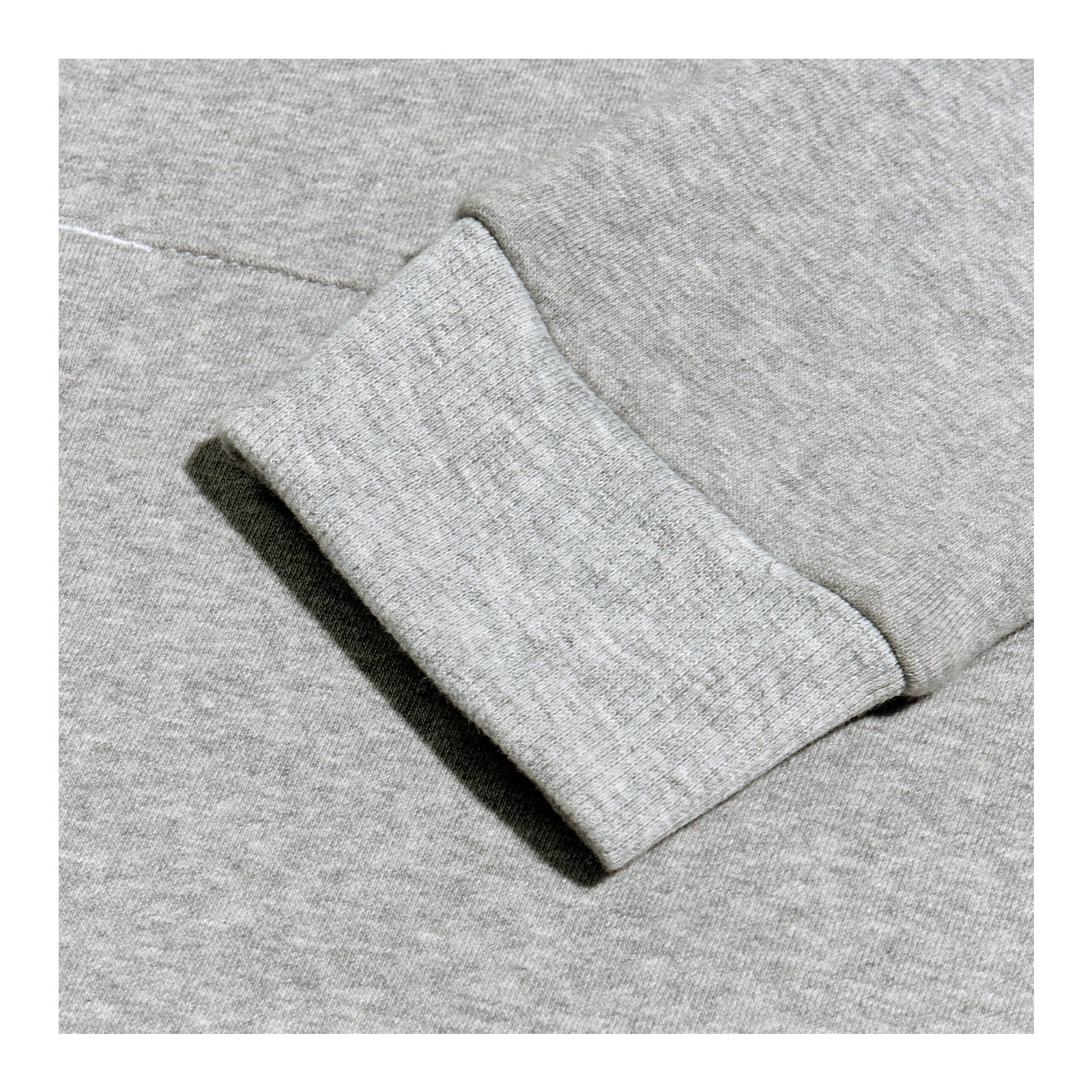 A gray sweatshirt is displayed prominently showing a close-up of a cuff where the fabric appears soft and textured against a uniform gray background.
