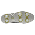 A golf shoe sole is depicted featuring six translucent cleats arranged in pairs with a prominent logo in the center of the sole highlighting its design for traction on grass surfaces.