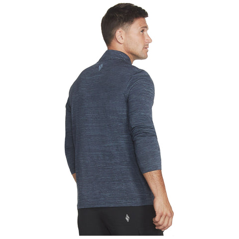 A man is wearing a dark navy long-sleeve athletic shirt with a high collar and looks over his shoulder revealing a stylish and casual appearance in a neutral setting.