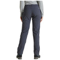 Gray outdoor pants are worn by a person standing with their back facing the viewer in a neutral setting suggesting comfort and readiness for activities in nature.