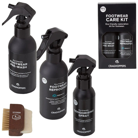 Three eco-friendly spray bottles labeled as footwear pre-wash footwear re-profiler and deodorising spray are arranged beside a wooden brush in a packaged footwear care kit by Craghoppers.