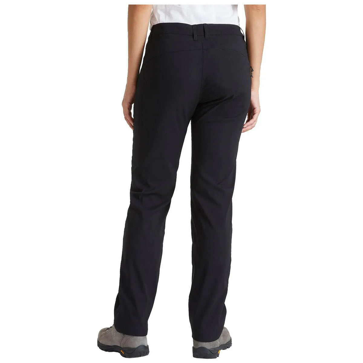 A person stands with their back to the viewer wearing black pants and gray footwear in a neutral setting highlighting the clothing details and fit without any additional context.