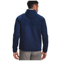 A person is viewed from behind wearing a dark blue jacket with a hood while standing in a neutral environment that emphasizes the outerwear without any distractions.