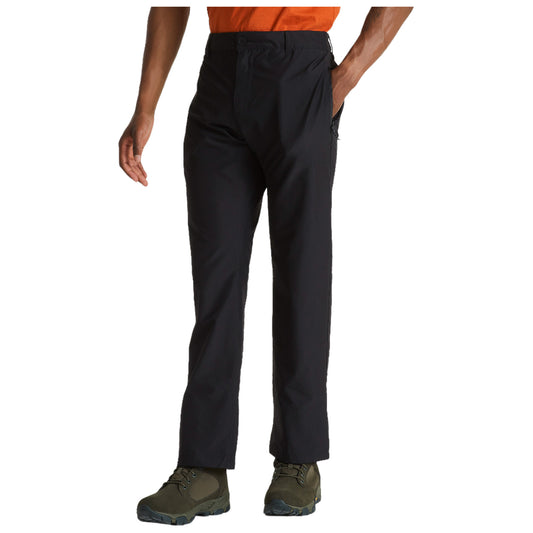 Black pants feature a casual fit and a slight sheen while a person stands with one hand in the pocket and the other relaxed at their side in a neutral setting.