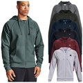 A man in a green zip-up hoodie stands in front of a display of various colored hoodies arranged vertically showcasing options for athletic wear in a neutral background setting.