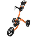 A golf push cart is positioned upright featuring a steel frame in bright orange with three large black wheels and a handle at the top designed for easy maneuverability on golf courses.