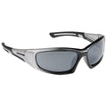 Sunglasses made of a silver and black plastic frame reflect light while resting on a surface showcasing their sleek design and tinted lenses suitable for outdoor use.
