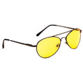 A pair of yellow-tinted sunglasses rests on a flat surface with brown metal frames highlighting their oval shape and slender arms designed for wearing while protecting eyes from bright light.