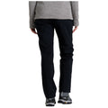 A person is wearing black pants and gray footwear standing upright wearing a gray top which suggests a casual outdoor or hiking context. They are facing away from the viewer.