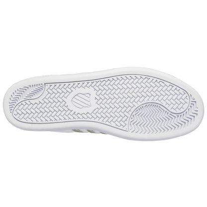 A white sneaker sole features textured patterns designed for traction while resting flat against a plain background, showcasing its clean lines and distinct tread design.