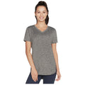 A woman stands confidently wearing a short-sleeved gray V-neck t-shirt with a relaxed fit showcasing a casual style against a plain white background.