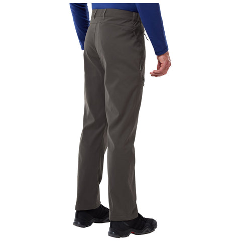A person stands with their back to the viewer wearing gray pants and black shoes while their left hand is slightly raised in an outdoor or casual setting.