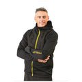 A man is smiling while wearing a zip-up, black hoodie with a quilted front and a yellow logo on the sleeve in a plain white background.