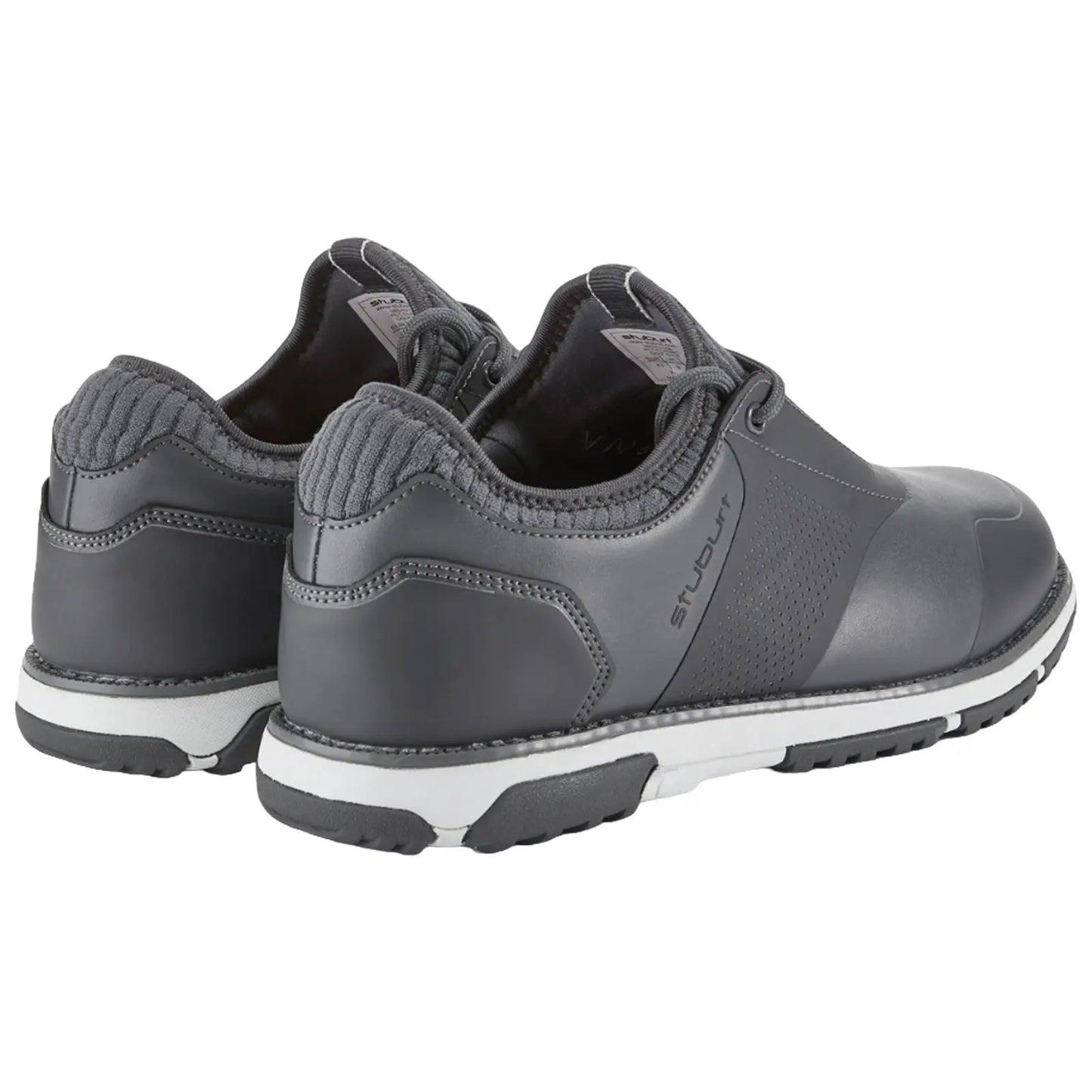 Gray athletic shoes are positioned side by side with a textured heel and white soles showing hints of wear in a neutral setting suggesting a casual or sporty environment.