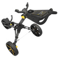 A golf push cart is positioned upright featuring large black wheels and a frame with yellow accents a handlebar is mounted above a storage compartment for golf accessories