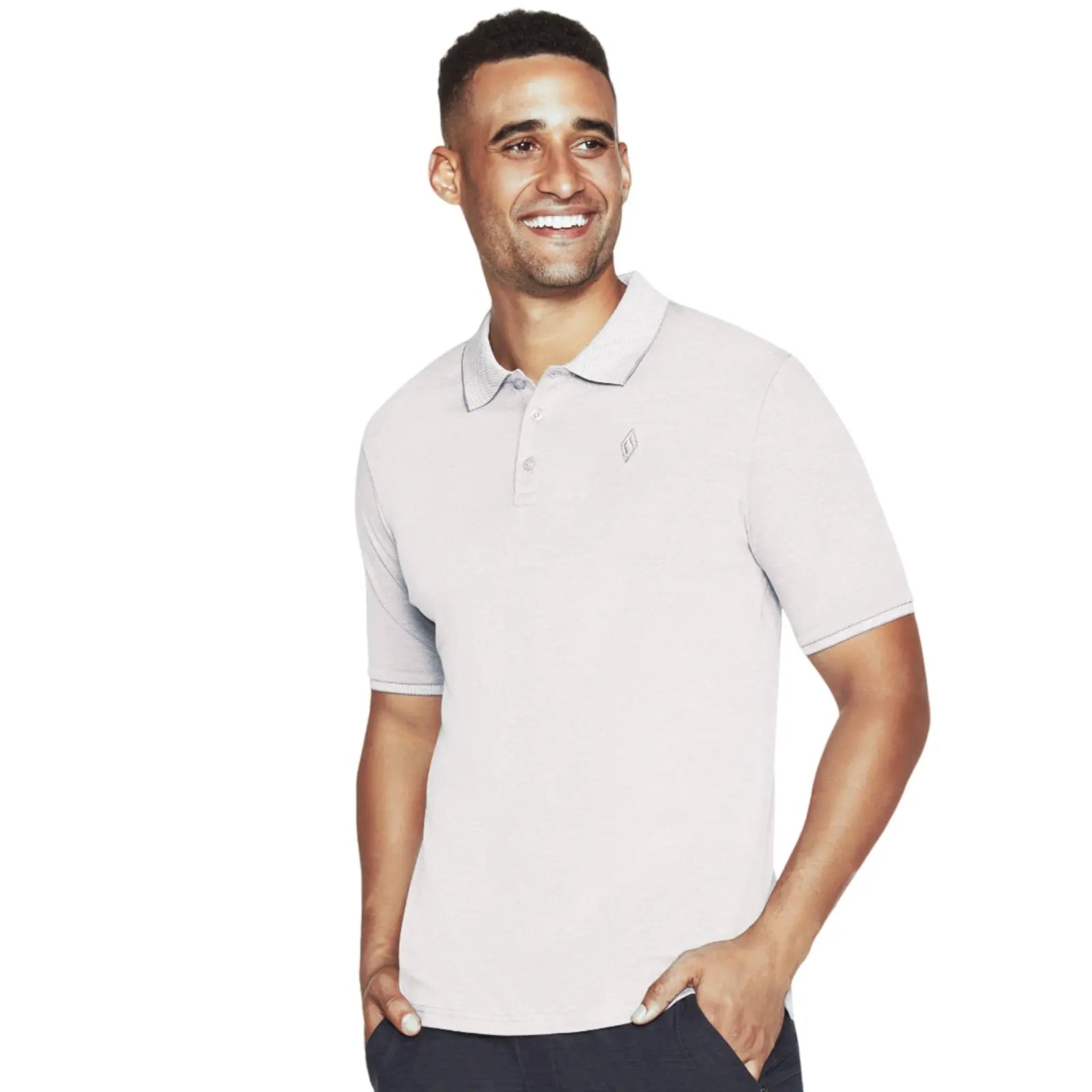 A young man is smiling while wearing a light gray polo shirt with a collar and a subtle logo on the left side standing in a plain white background.