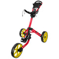 A red golf push cart with yellow wheels is standing upright showcasing its adjustable handle and storage compartment, designed for transporting golf bags on grassy courses.