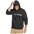A man wearing a black hoodie with the word Skechers printed in white lowers his head while running his hand through his hair, set against a plain white background.