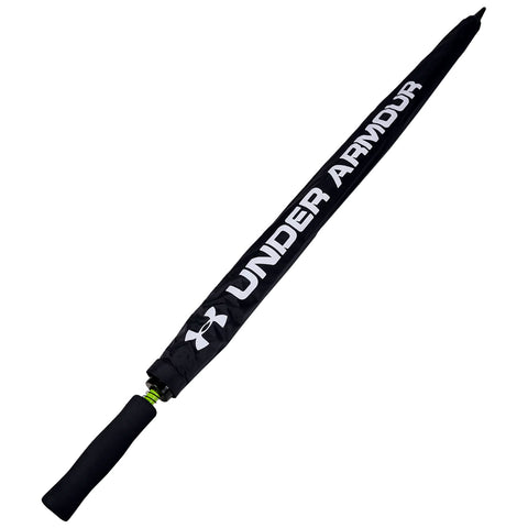A black umbrella with a textured handle featuring the Under Armour logo is closed and positioned vertically against a plain white background, indicating its storage or readiness for use.