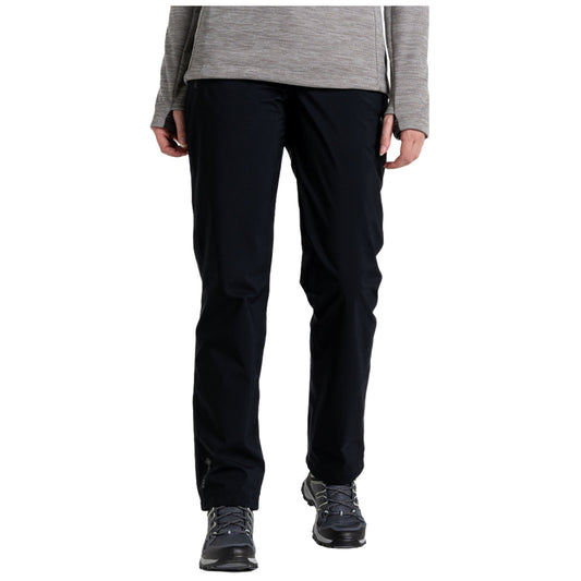 Black pants are being worn by a person who is standing upright with both hands visible near their waist in a neutral indoor setting with a plain background.