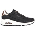 A black athletic shoe with a sleek design features a white midsole and a metallic bronze accent on the heel while displaying the brand name Skechers prominently on the side.