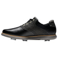 A black golf shoe features a sleek design with layered materials and decorative perforations. It is positioned on a white background, highlighting its cleated sole and contrasting colors.