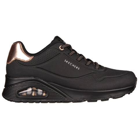 Black sneaker with a sleek design features a glossy copper accent at the heel and a visible air cushion in the sole showcasing the brand name Skechers on the side.