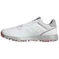 A white athletic shoe with gray accents is positioned sideways displaying its smooth surface and textured mesh details while the sole features visible spikes designed for grip on grass or turf.