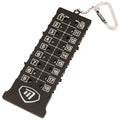 A black disc golf scorekeeper displays numbered holes from one to eighteen allowing players to record scores with small discs organized in holes on a portable device with a keychain attachment.