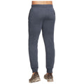Gray sweatpants are being worn by a person facing away from the viewer demonstrating a casual outfit in a neutral setting with no additional context visible.