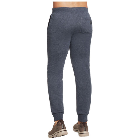 Gray sweatpants are being worn by a person facing away from the viewer demonstrating a casual outfit in a neutral setting with no additional context visible.
