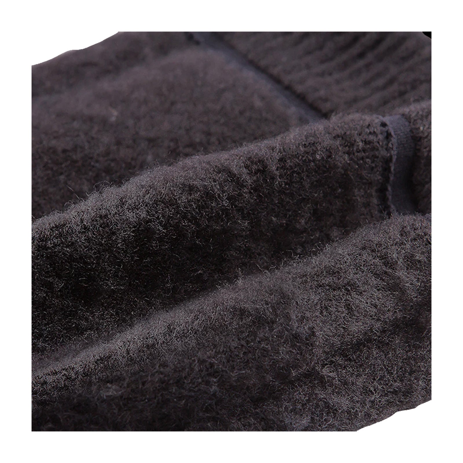 A dark, textured fabric lies in folds showcasing its soft and fuzzy surface suggesting warmth and comfort in a close-up view with no distinct background elements visible.