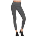 Gray leggings are being worn by a person standing upright showcasing a high waistband and a fitted design paired with black athletic shoes in a neutral background setting.