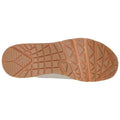 A shoe sole features a textured pattern with various grooves and shapes designed for traction the sole is viewed from the bottom against a plain white background.