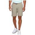 A man stands wearing light beige shorts and white athletic shoes with green accents His left hand rests on the hip while he faces forward in a neutral setting