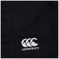 A black fabric displays a white embroidered logo featuring three stylized waves and the word canterbury below it representing a sportswear brand in a casual setting.