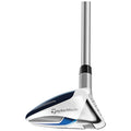 A golf club with a white and blue head is positioned upright showcasing its angled face and sleek design ready for use on a golf course or practice range environment.