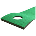 A green felt mat with a circular hole is resting on a black base The mat is designed for activities like putting in golf or similar sports contexts