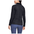A person wearing a black athletic pullover stands with their back facing the viewer in a light environment showcasing the clothing's texture and style.