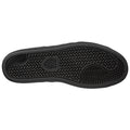 A black sneaker sole rests flat showcasing a textured pattern with various grooves and ridges designed for traction in diverse environments providing stability and grip during movement