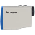 A compact rangefinder with a blue accent and buttons is balanced in hand for measuring distances on the golf course featuring the text Ben Sayers prominently displayed on the body.
