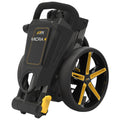 A compact golf cart is folded for storage with a sleek black frame and yellow accents. It features a padded handle and large wheels designed for maneuverability on the course.